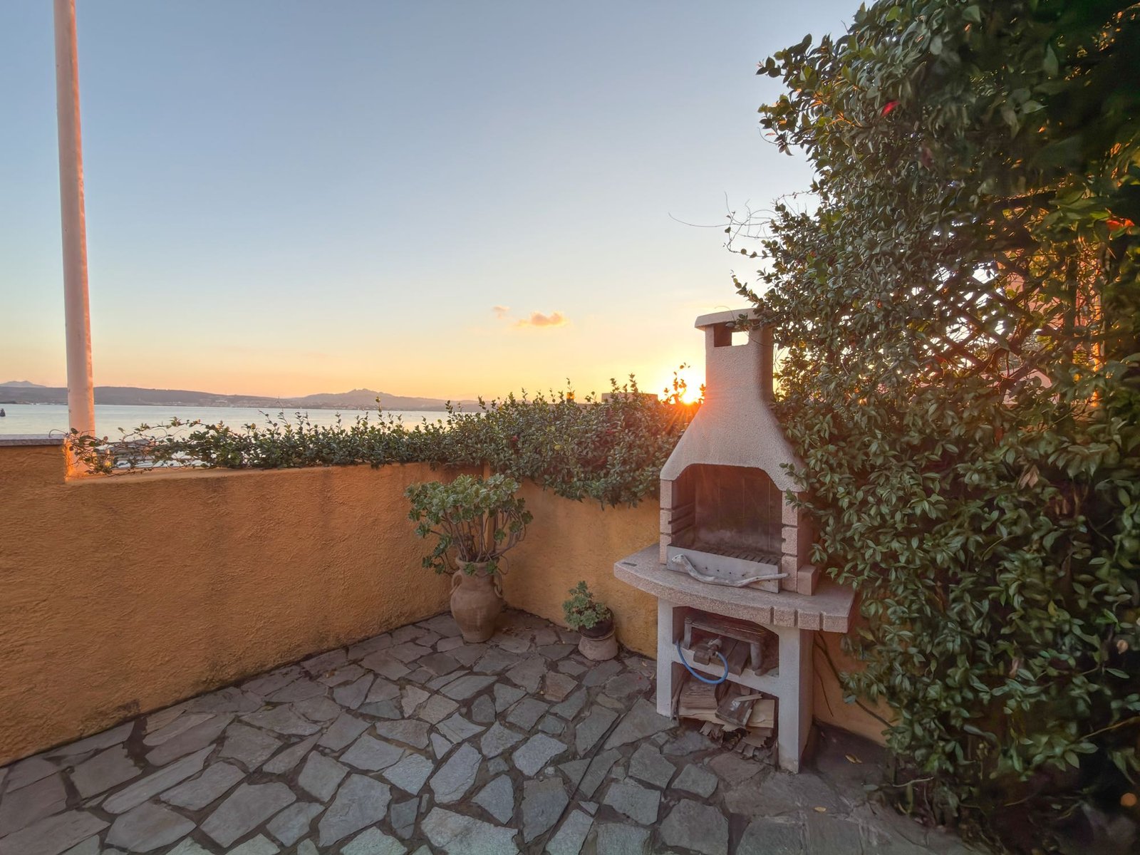 Barbecue in muratura affacciato sul mare al tramonto