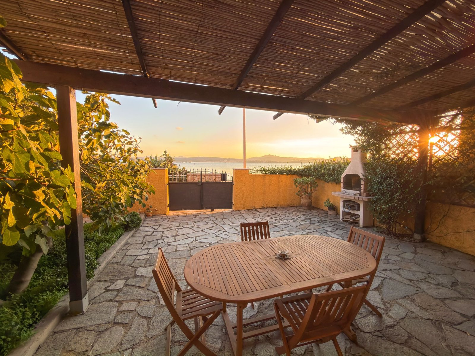 Terrazza in pietra con tavolo sotto il pergolato